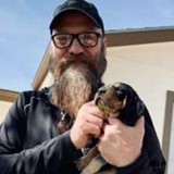 Photo of Doug Johannessen holding a puppy