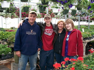 Owner operators of Harvest Gardens, the Johnston family, surrounded by plants and flowers in the garden center